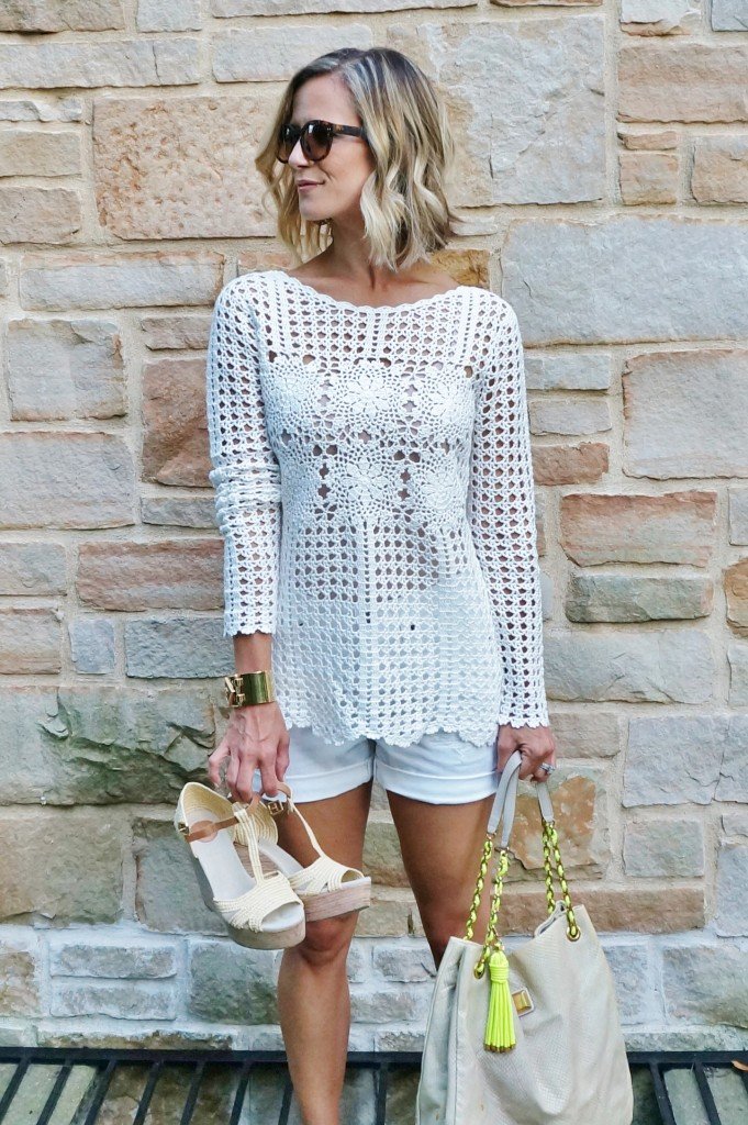 Neutral sweater, white shorts, tote, wedges, and sunglasses