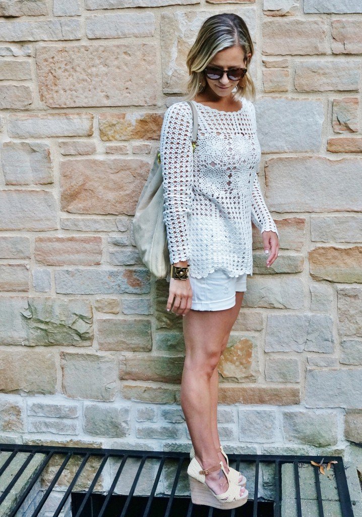 Neutral sweater, white shorts, tote, wedges, and sunglasses