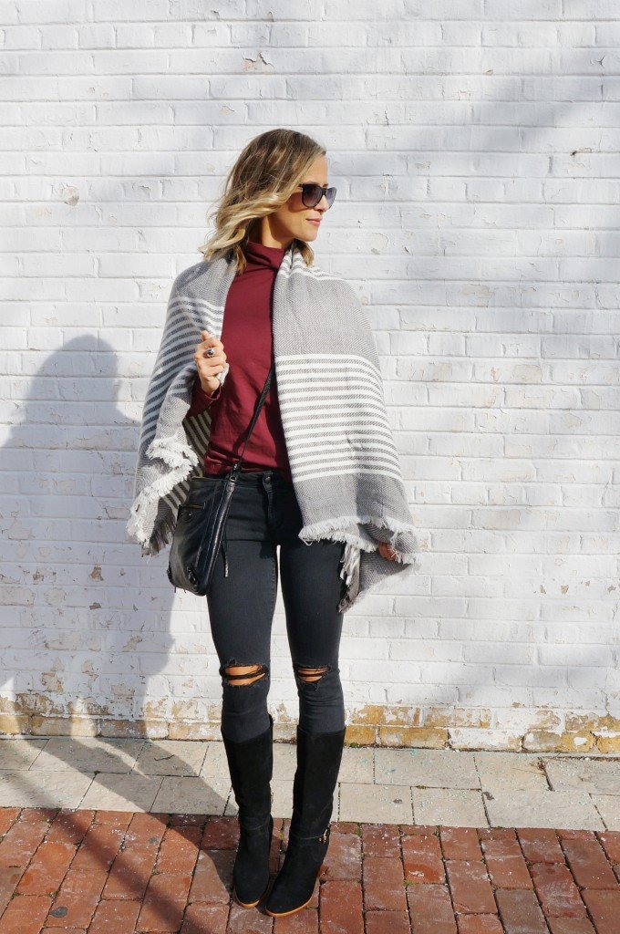Thanksgiving outfit: burgundy turtleneck, poncho, black denim, boots, crossbody