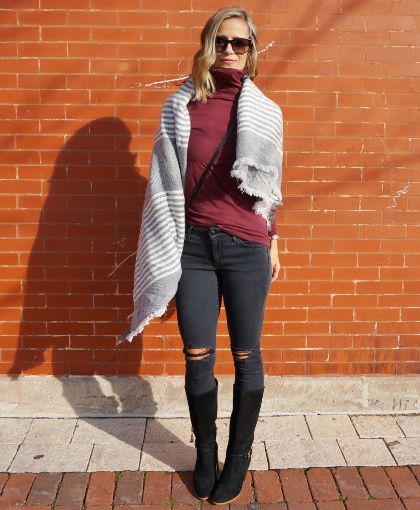 Thanksgiving outfit: burgundy turtleneck, poncho, black denim, boots, crossbody