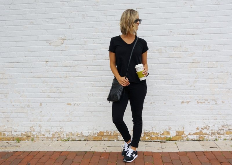 Black tee, black denim, sneakers, and crossbody