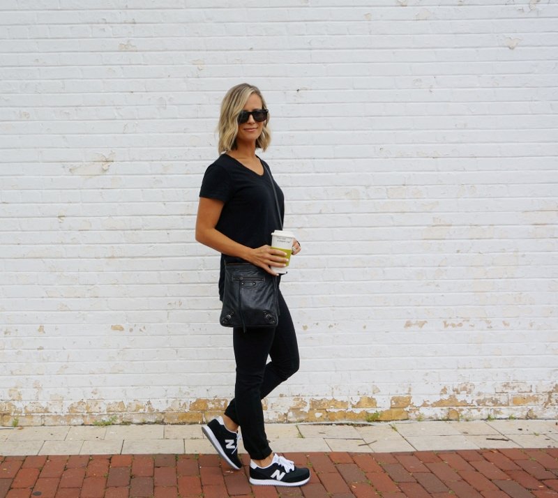 Black tee, black denim, sneakers, and crossbody