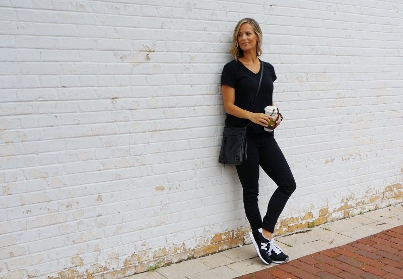 Black tee, black denim, sneakers, and crossbody