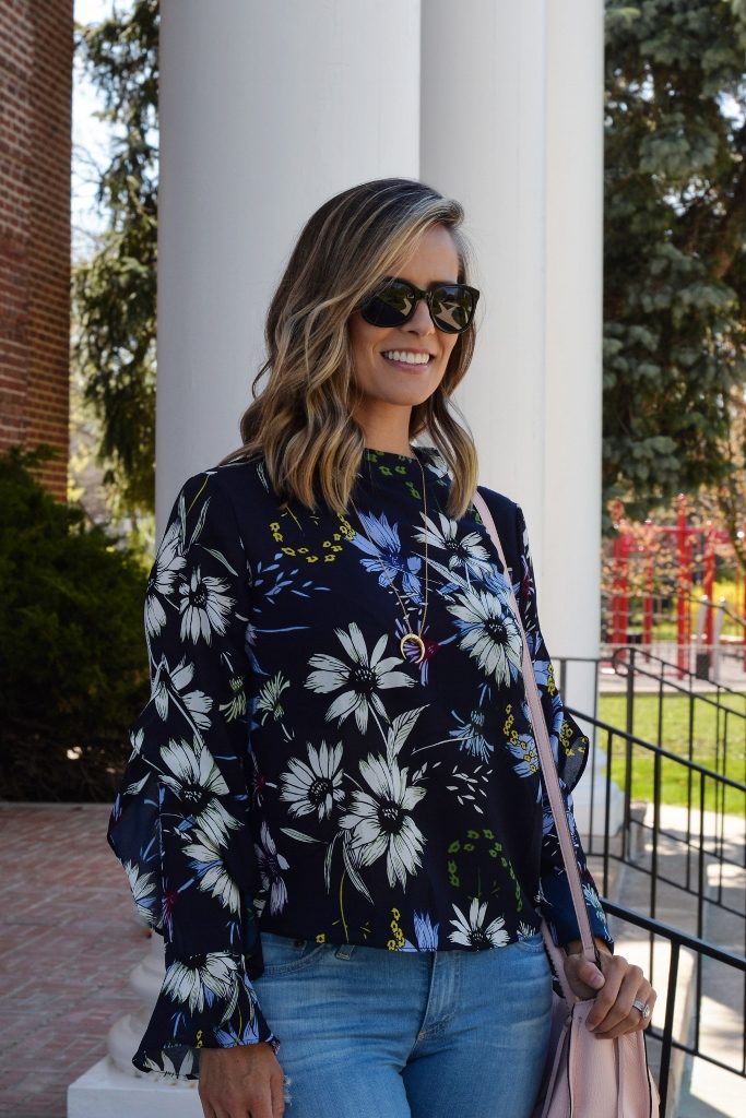 Floral top, denim, sunglasses, pink purse, and heels