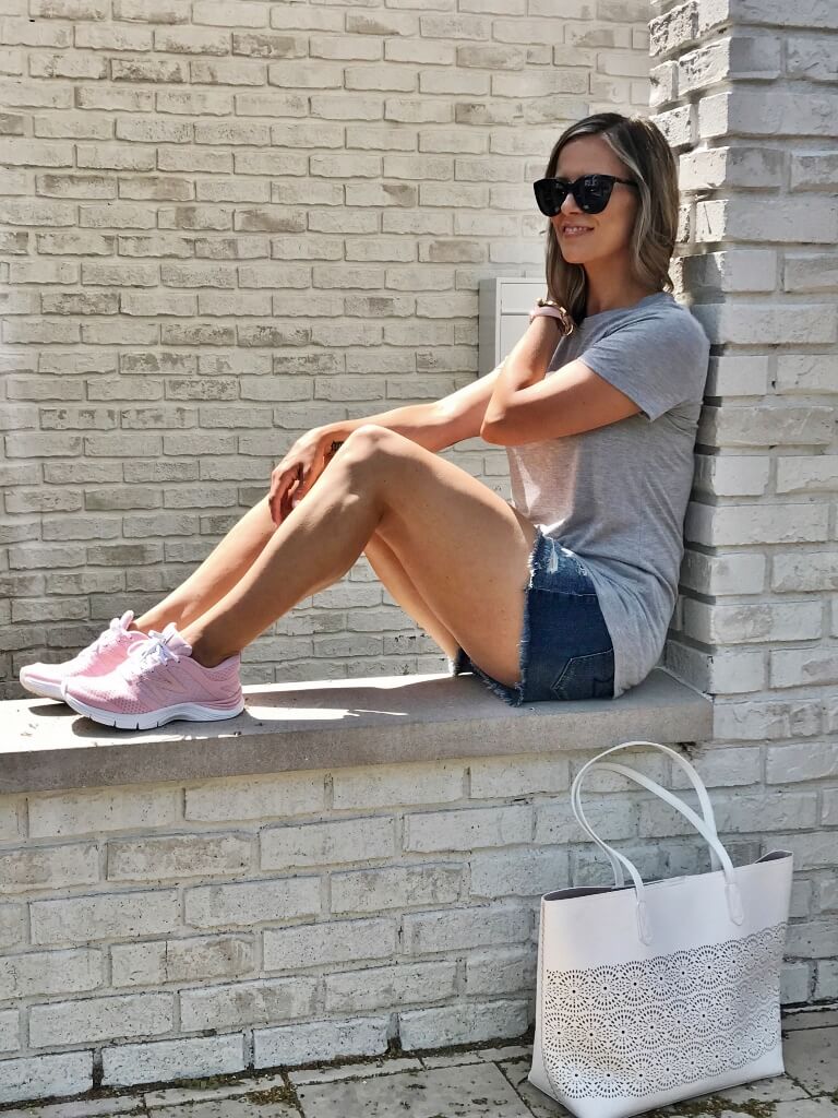 Graphic tee, cut off shorts, tote, sunglasses, and sneakers