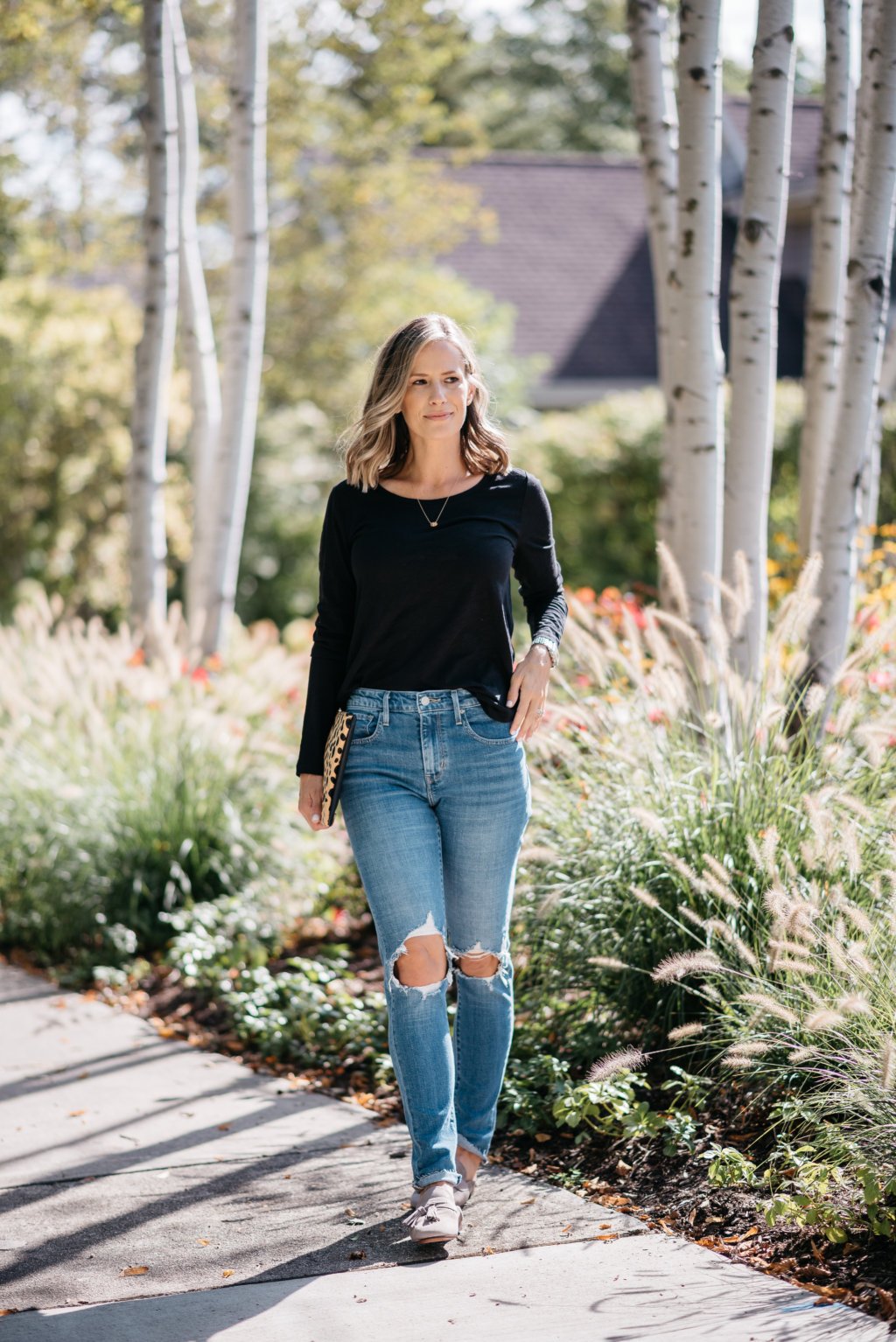 Black long sleeve tee, mom jeans, mules, and clutch