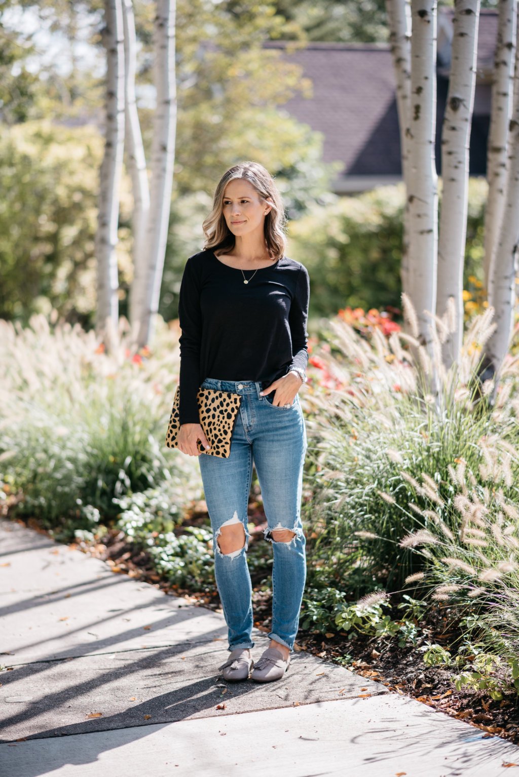 Black long sleeve tee, mom jeans, mules, and clutch