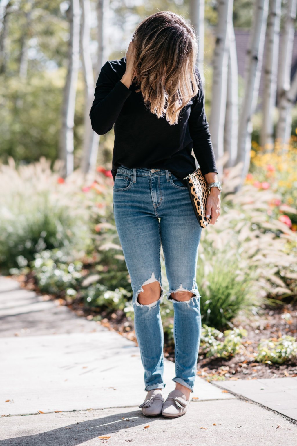 Black long sleeve tee, mom jeans, mules, and clutch