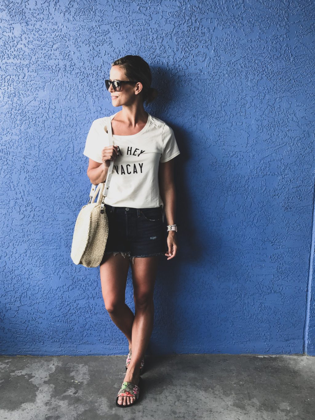 Beach vacation style, graphic tee, cut off shorts, straw tote, slides