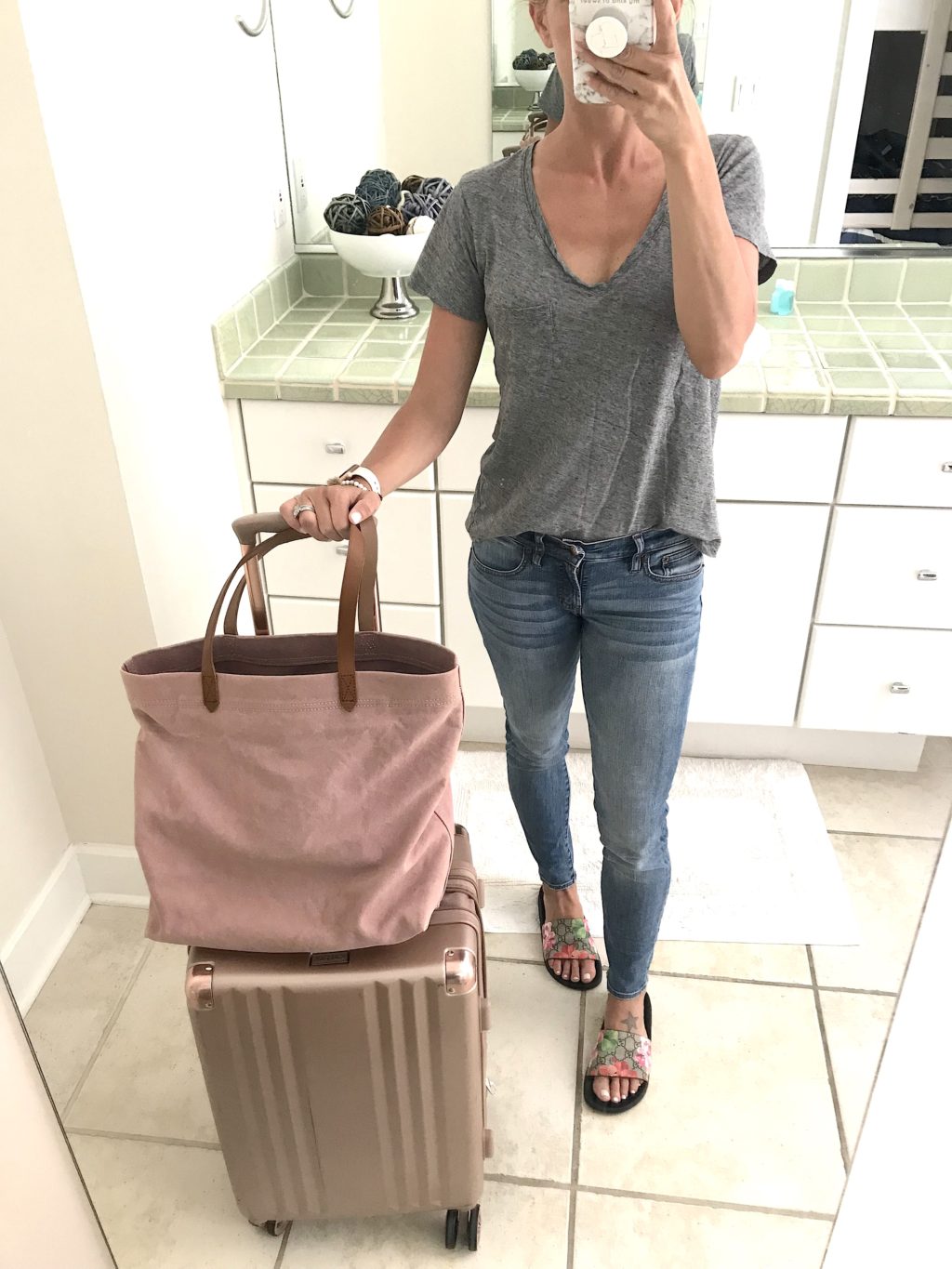 Beach vacation style, travel outfit--grey tee, denim, sandals, and pink tote
