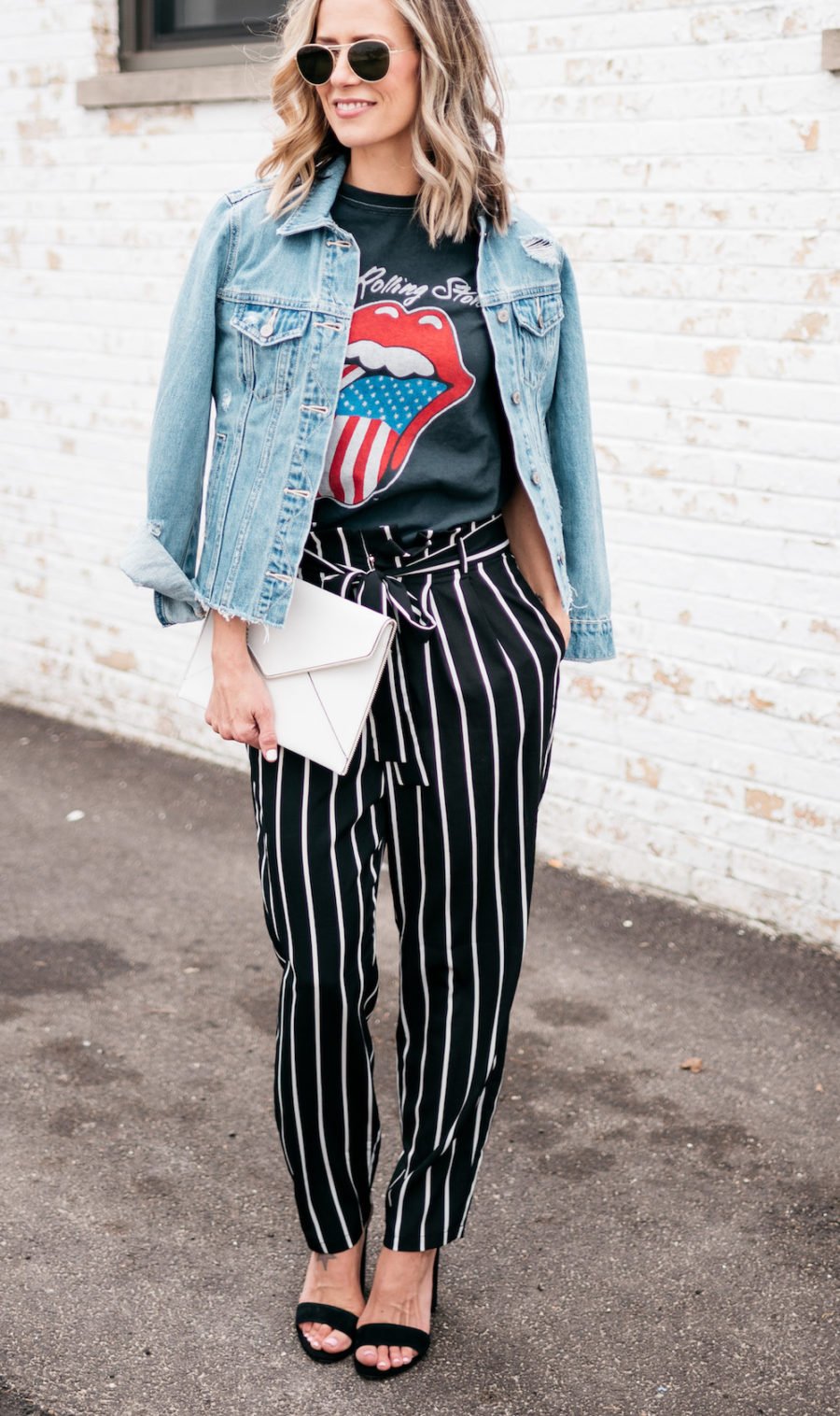 Band tee, striped pants, denim jacket, heels, clutch