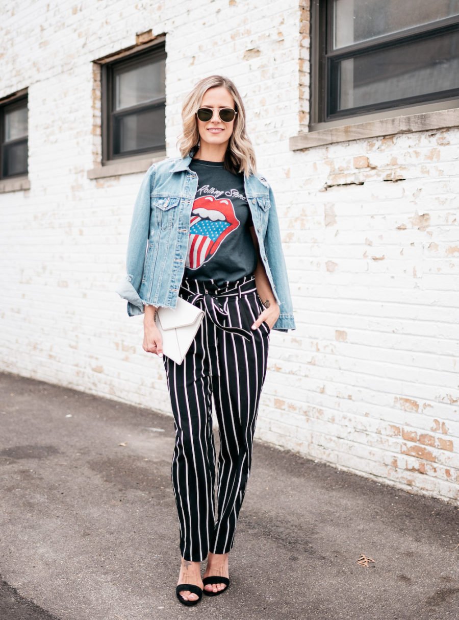 Band tee, striped pants, denim jacket, heels, clutch, sunglasses