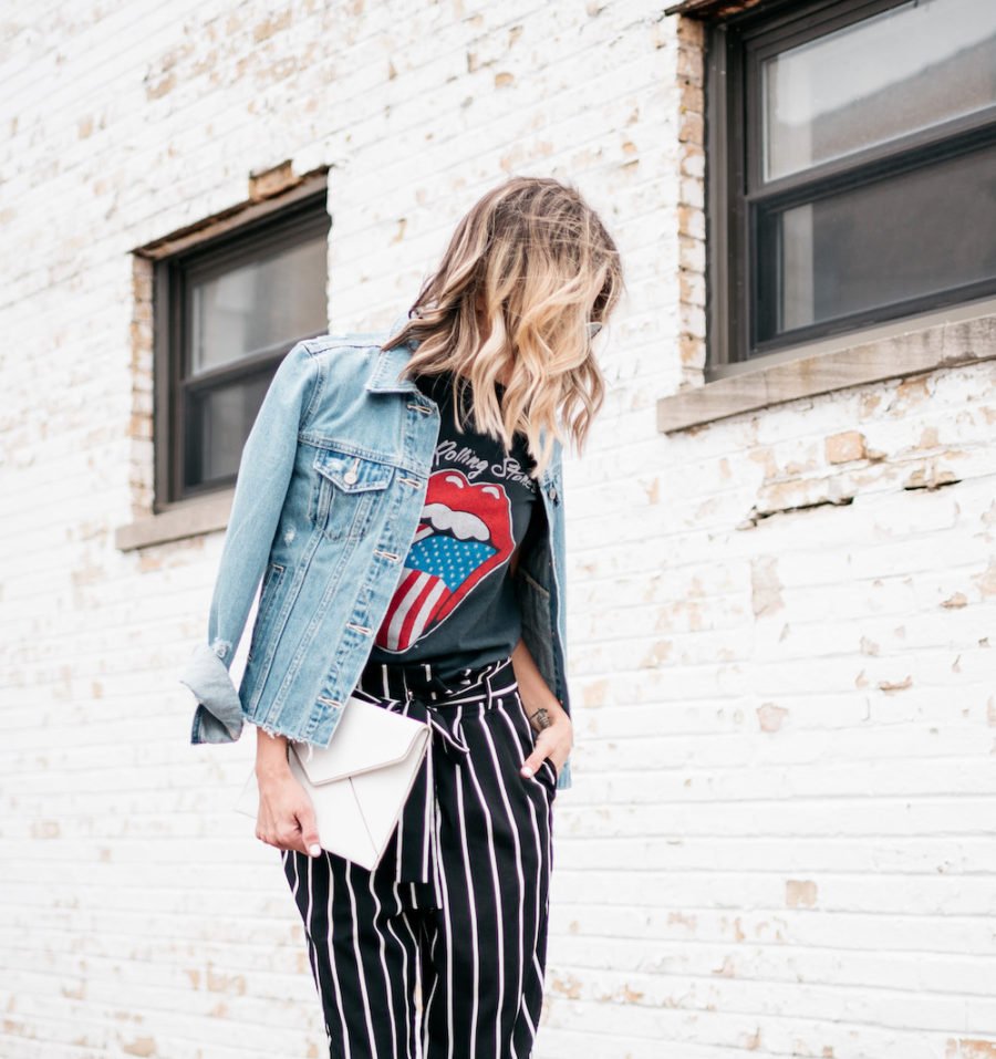 Band tee, striped pants, denim jacket, heels, clutch, sunglasses