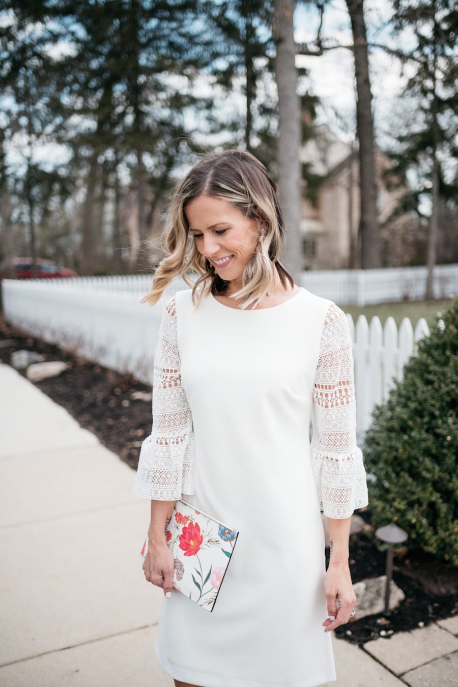 White lace dress, floral clutch, pink pumps