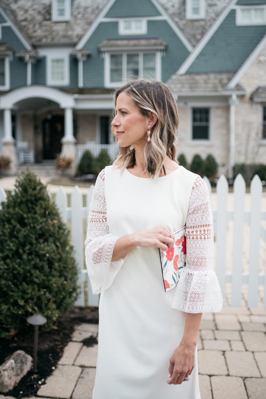 White lace dress, floral clutch, pink pumps