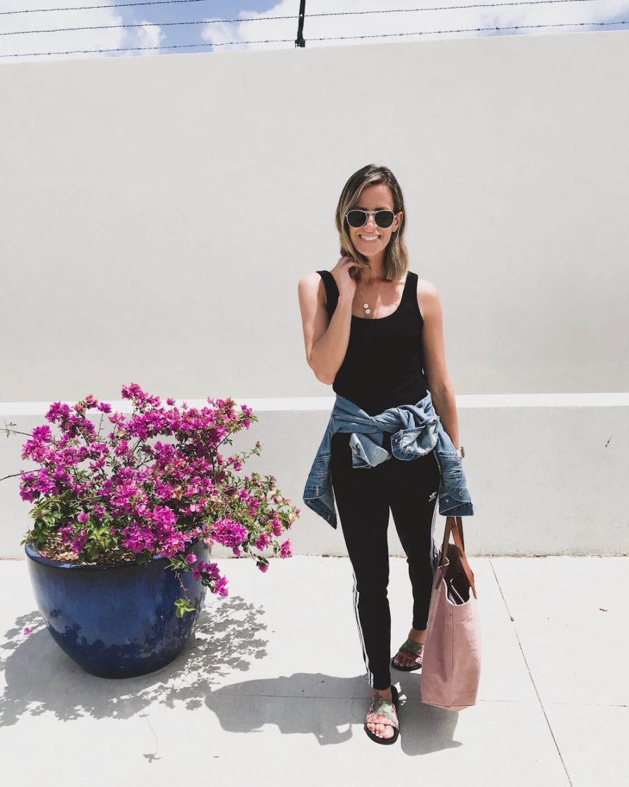 Travel outfit, Adidas pants, tank, slides, denim jacket, and tote