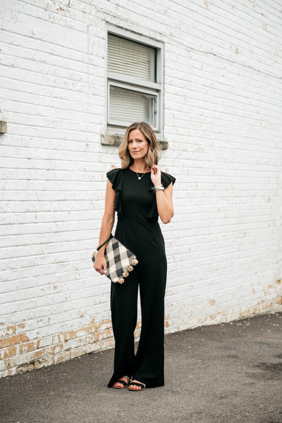 Black jumpsuit, sandals, clutch