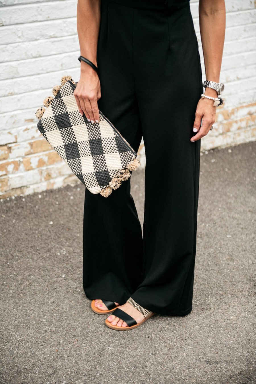 Black jumpsuit, sandals, clutch