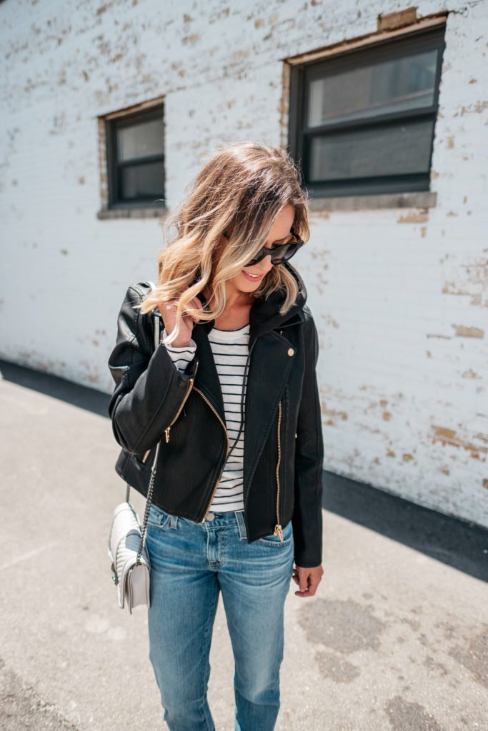 Black faux leather jacket, striped tee, denim jeans