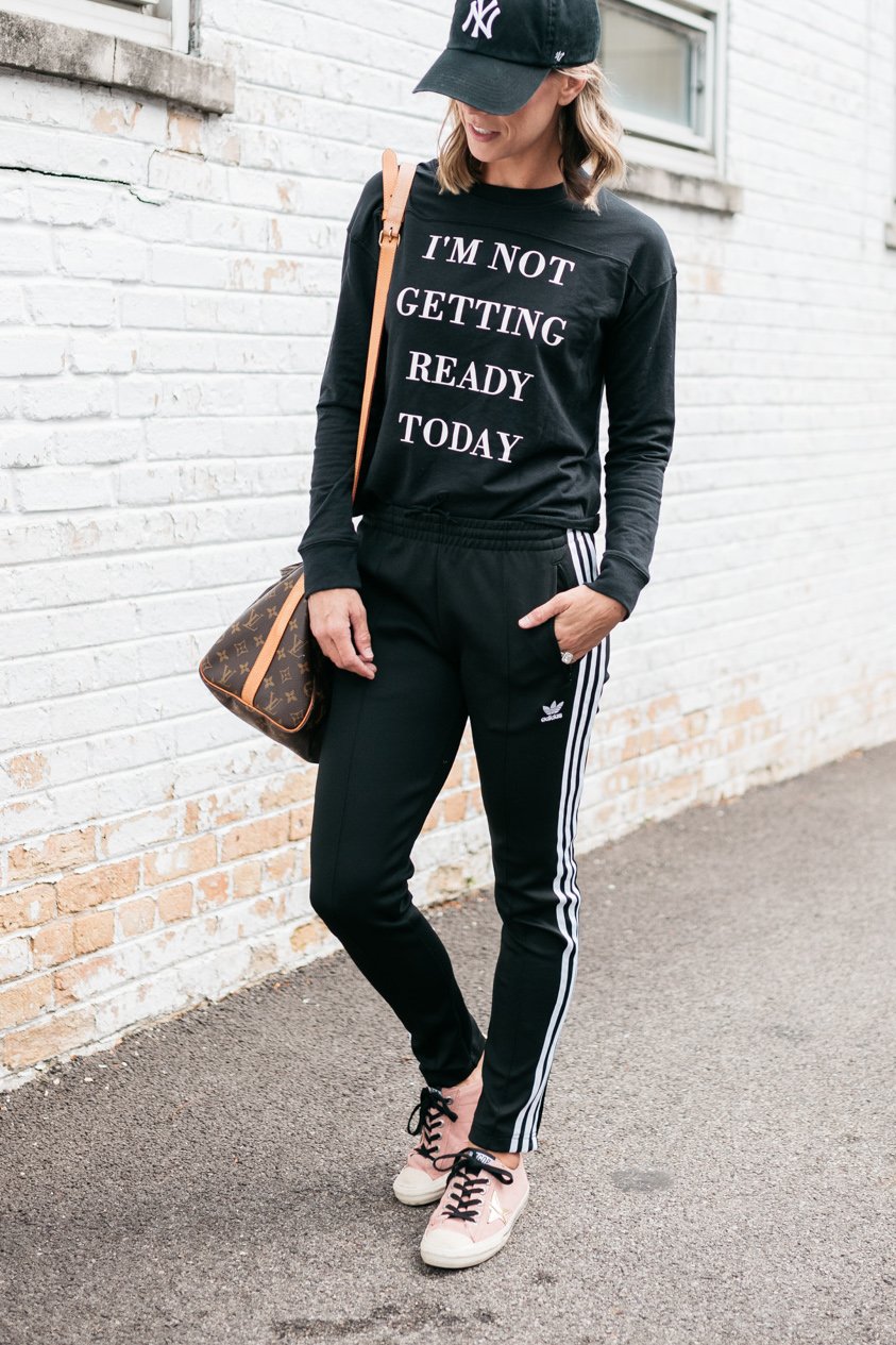 Pullover, Adidas track pants, Louis Vuitton bag, Nike hat, Golden Goose deluxe brand sneakers