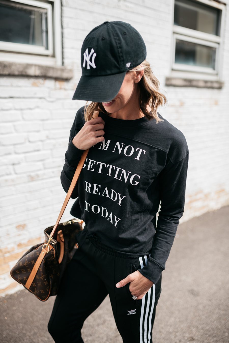 Pullover, Adidas track pants, Louis Vuitton bag, Nike hat