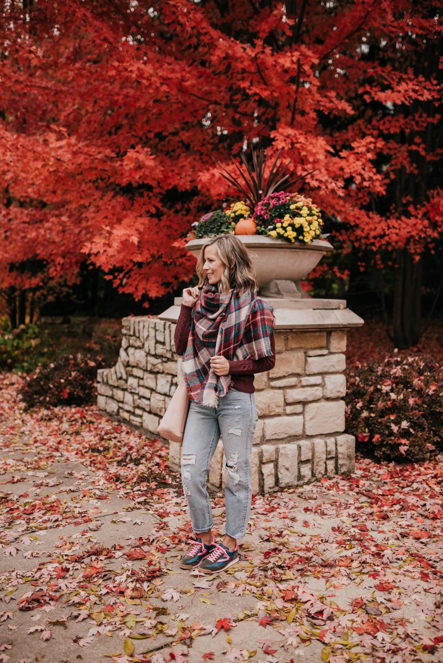 Thanksgiving Outfit Idea, cable knit sweater, plaid scarf, denim, sneakers, and tote bag