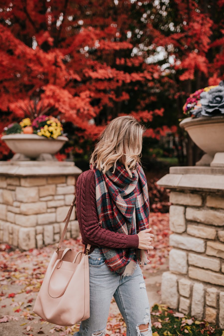 Thanksgiving Outfit Idea, cable knit sweater, plaid scarf, denim, sneakers, and tote bag