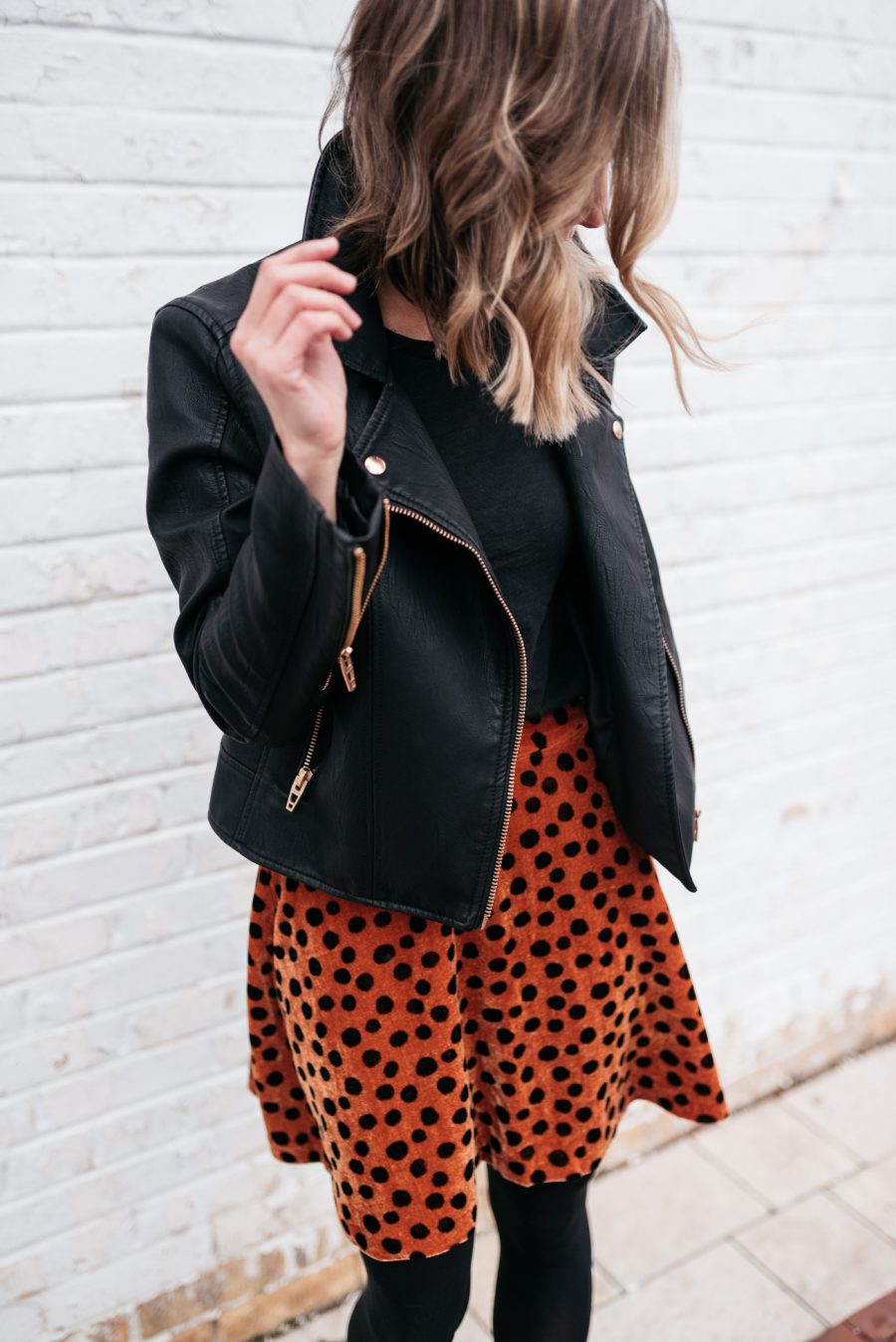Cozy holiday party outfit: leopard skirt, tights, booties, and moto jacket