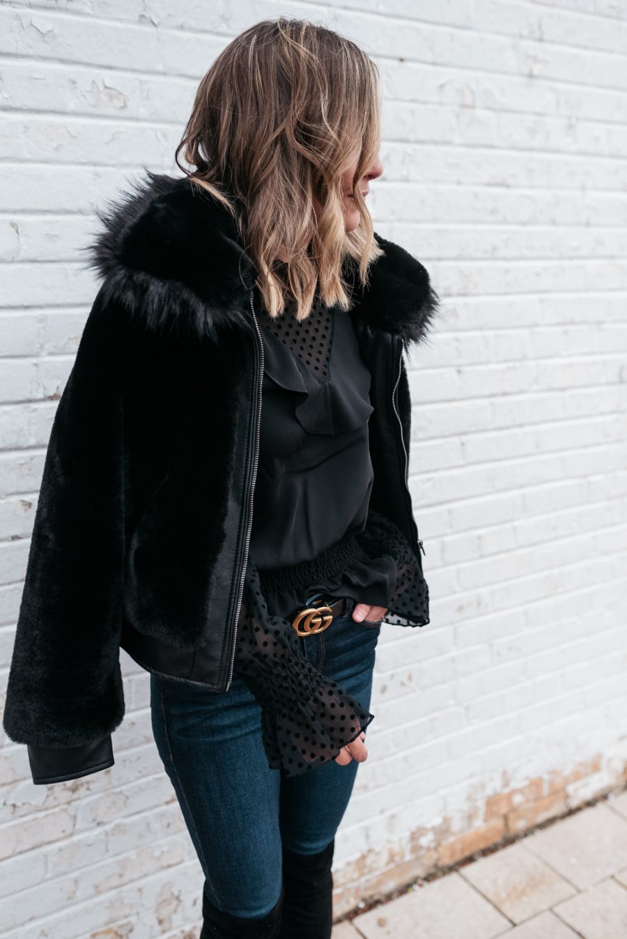 Faux fur jacket, black blouse, skinny jeans, and over the knee boots