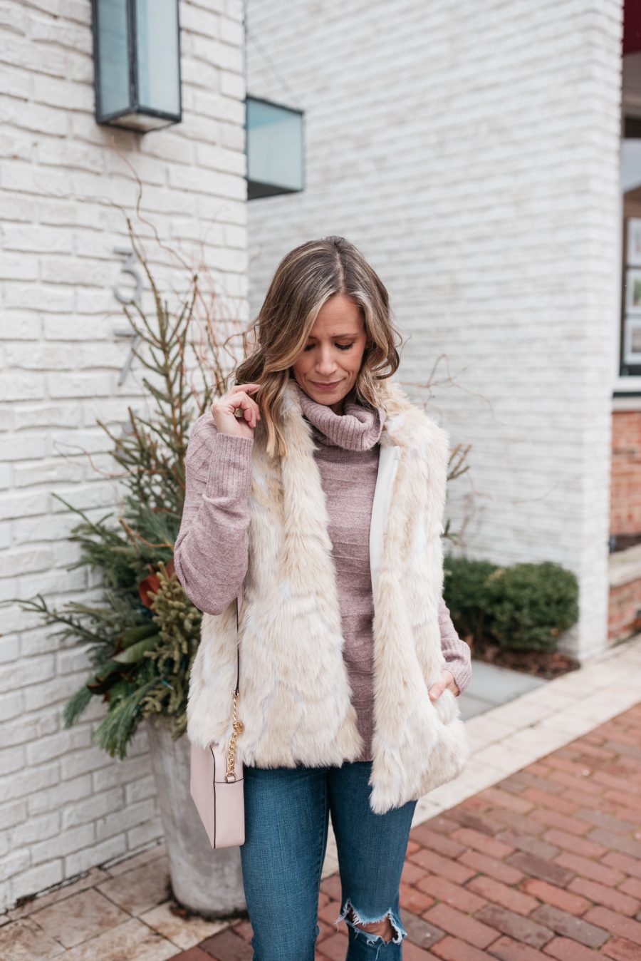 pink turtleneck, faux fur vest, skinny jeans, crossbody, and booties
