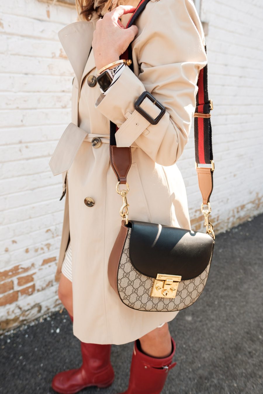 $30 sweatshirt dress with a trench coat, rain boots, and crossbody bag