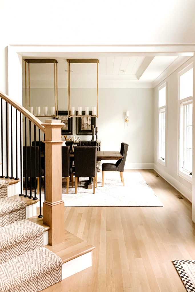 A warm and welcoming dining room of neutrals, comfortable seating, and beautiful accent lighting and art
