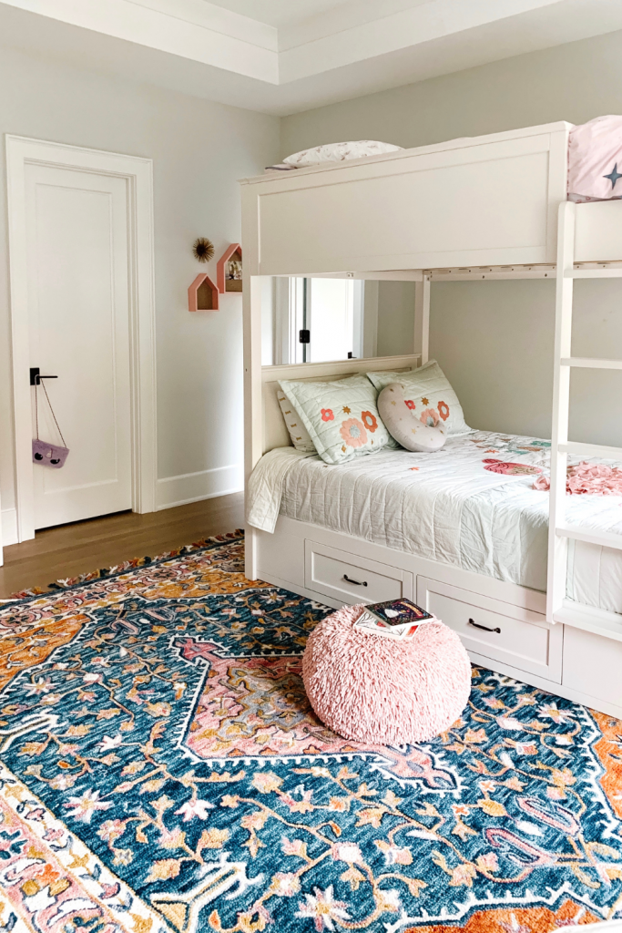 Transition to a big girl bedroom with bunkbeds, vibrant pops of color, and a cozy reading area.