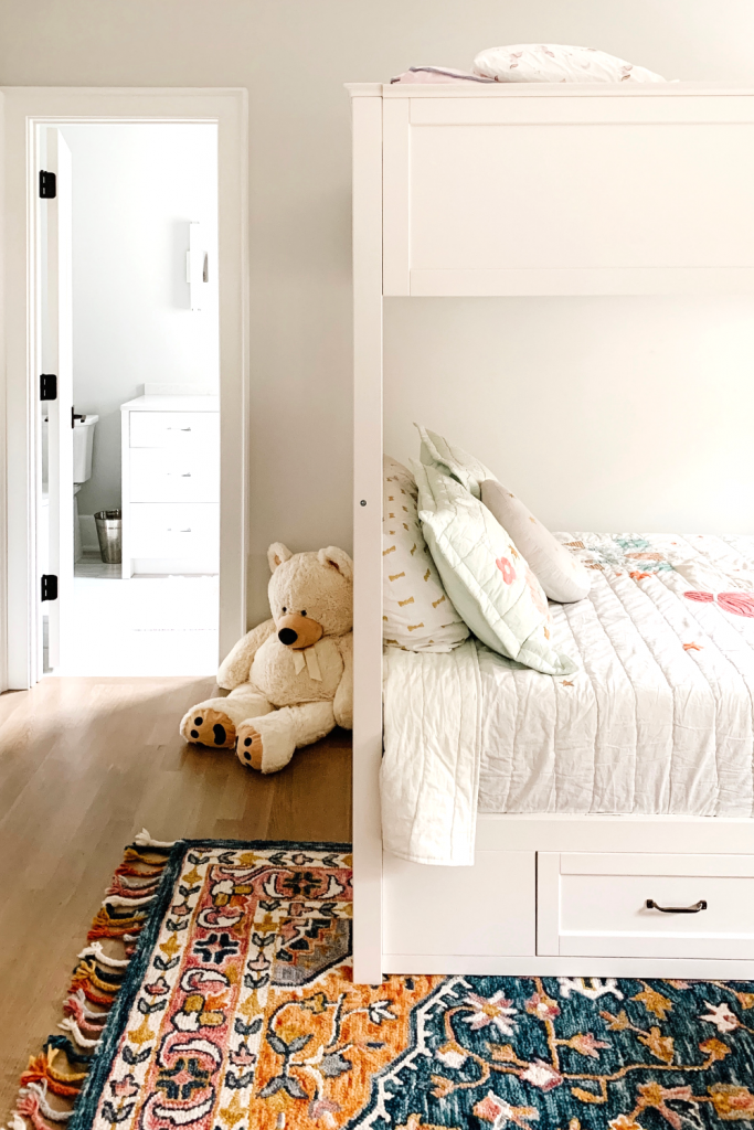 Transition to a big girl bedroom with bunkbeds, vibrant pops of color, and a cozy reading area.
