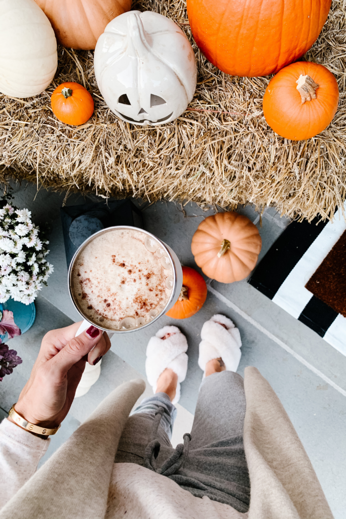 We gave our front porch a fall makeover complete with a freshly painted black door, pumpkins, mums, and a hay bail.