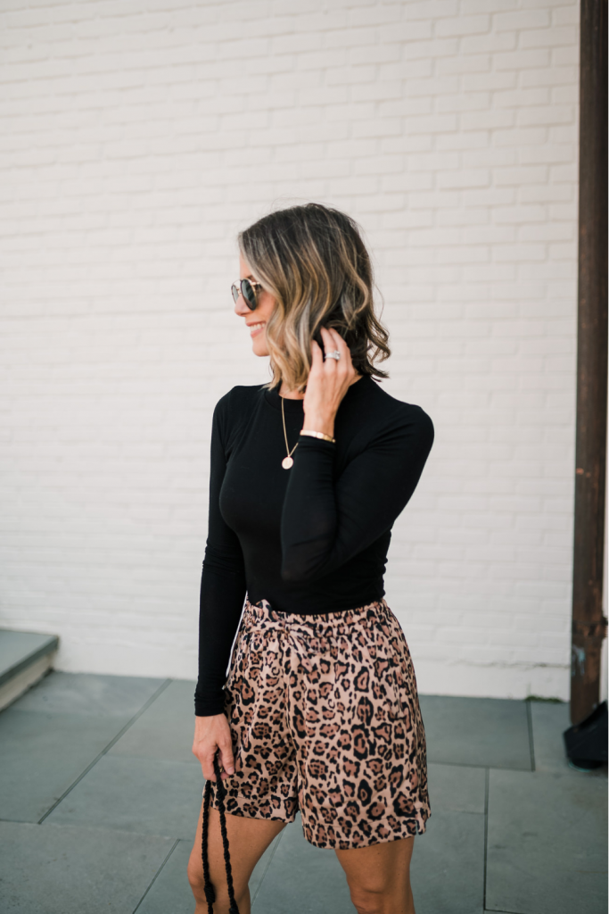 Long sleeve black tee, bucket bag, leopard shorts, sandals