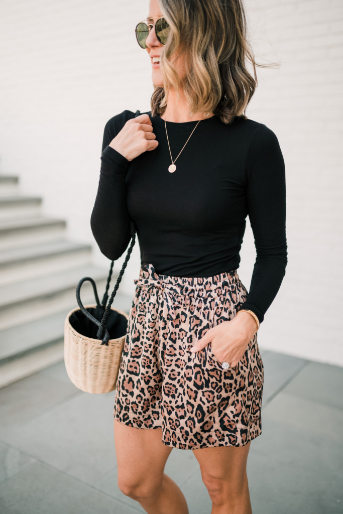 Long sleeve black tee, bucket bag, leopard shorts, sandals