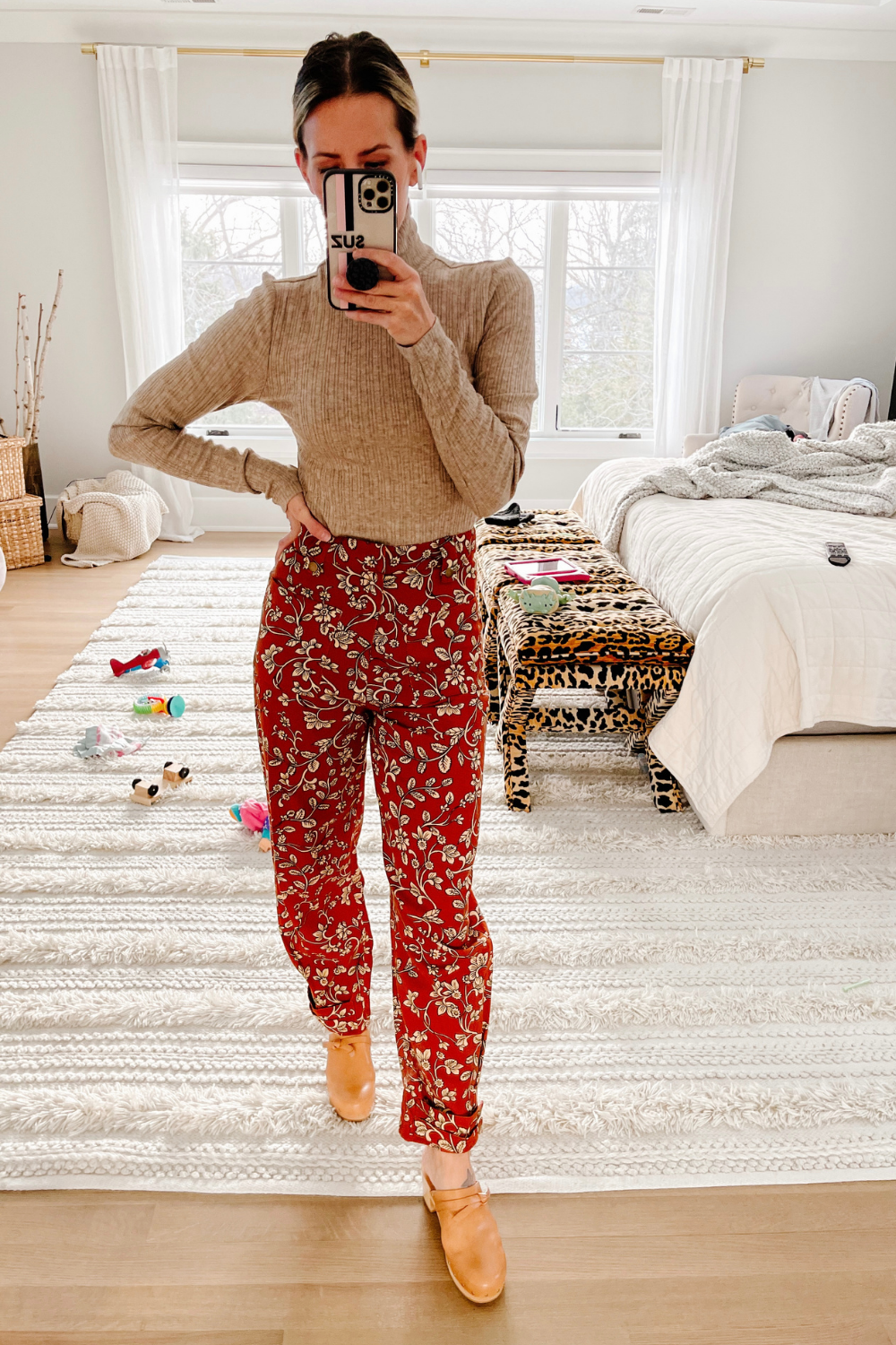 Suzanne wearing a sweater, printed pants, and clogs