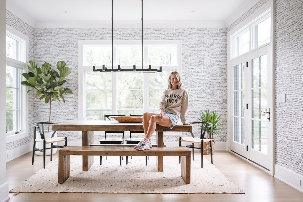 Suzanne sitting on a dining room table in her kitchen nook 
