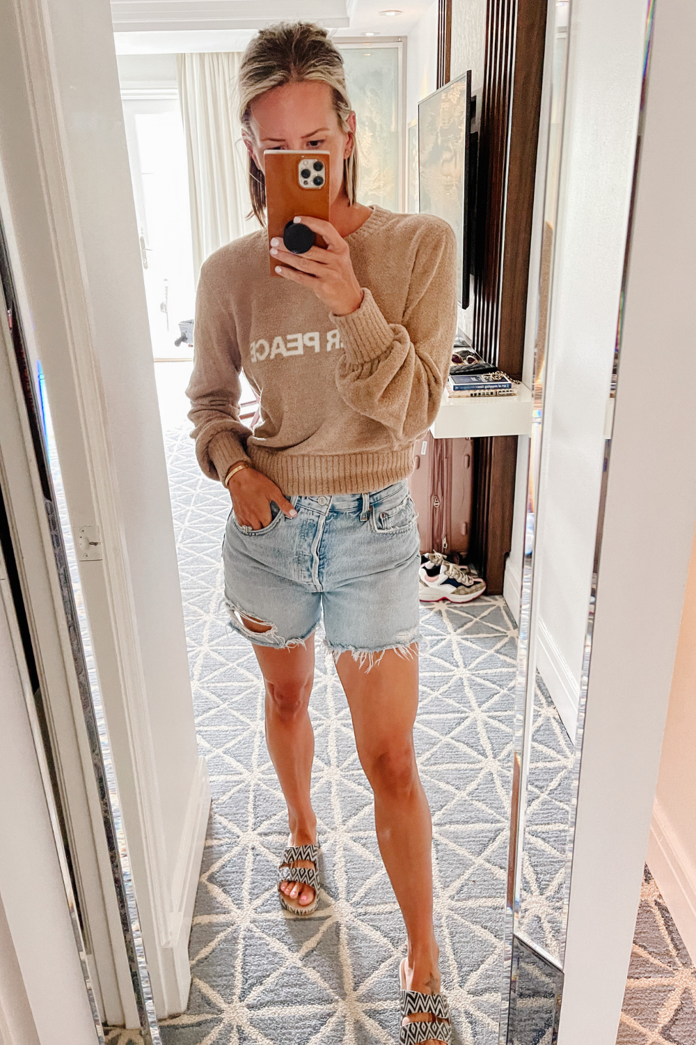 Suzanne in a sweater, shorts, and slides