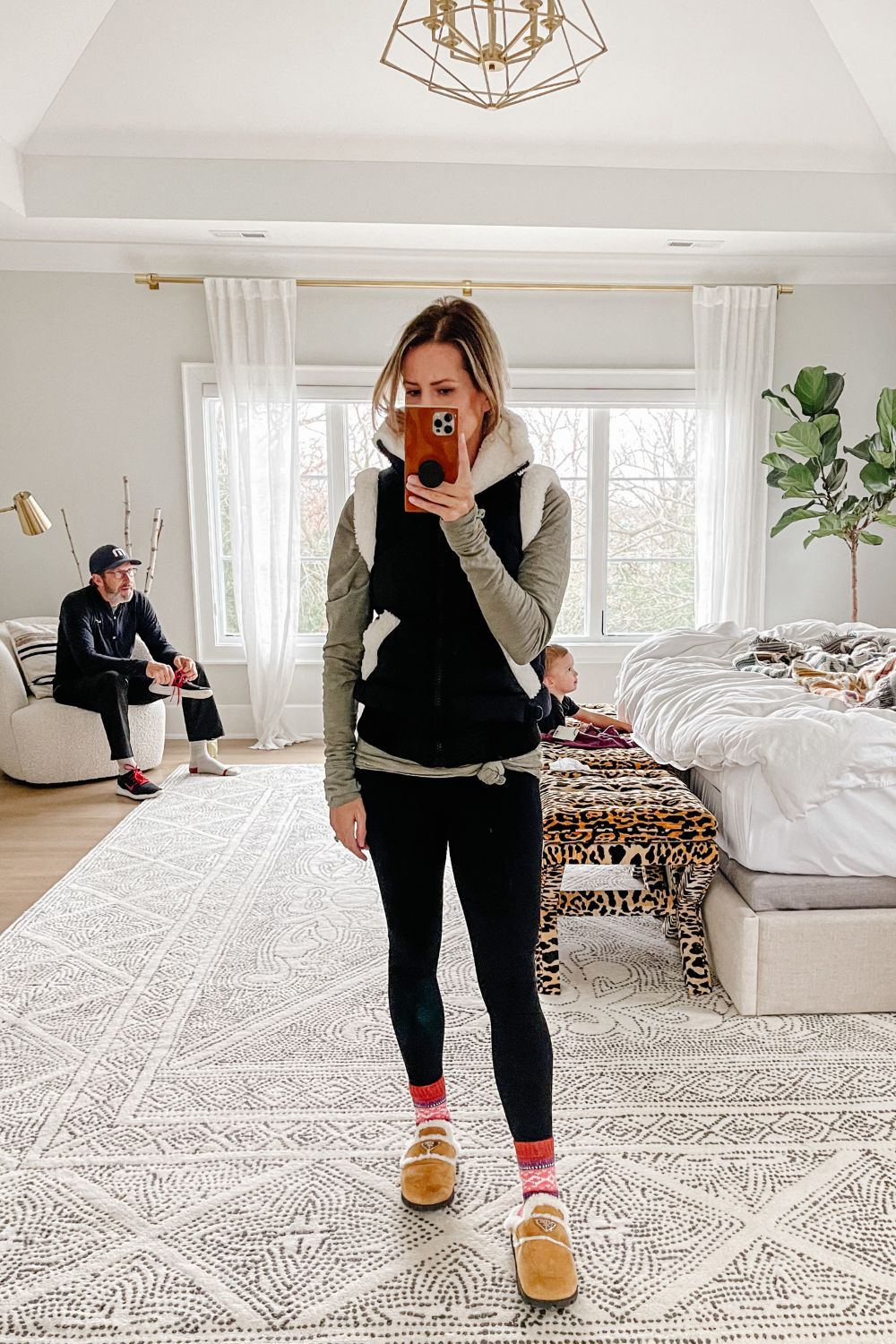 Suzanne wearing a vest, long sleeve tee, leggings, and Prada slides