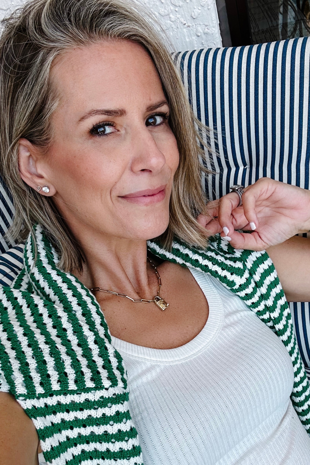 Suzanne sitting in a lounger on vacation wearing a tank and sweater