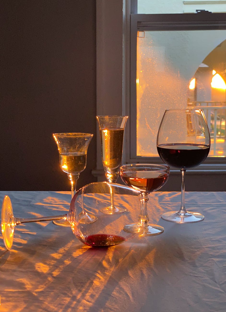 glasses with alcoholic drinks placed on table in room in sunny day